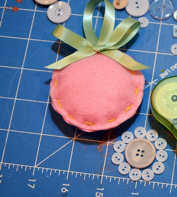 glue-dots-felt-ornament-set-stuffed-with-ribbon-buttons-laid-out.jpg